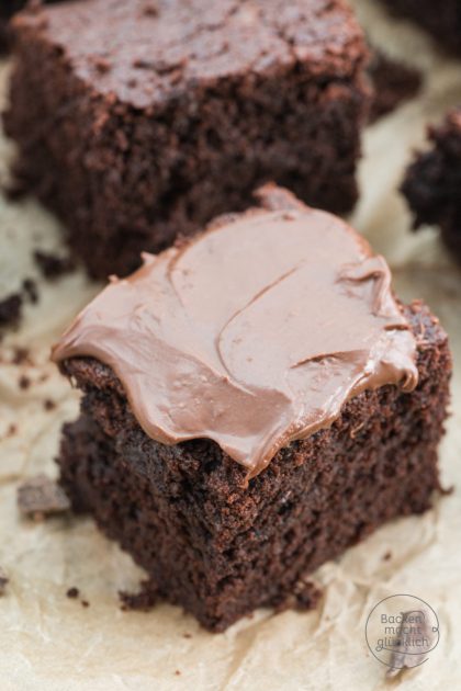 Schokoladige Nutella-Brownie-Stücke mit glänzendem Nutella-Frosting auf Backpapier