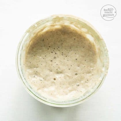 Blasiger Sauerteig im Glas von oben fotografiert