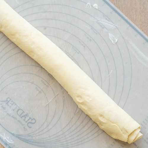 Aufgerollter Hefeteig auf bemehlter Silikon-Backmatte
