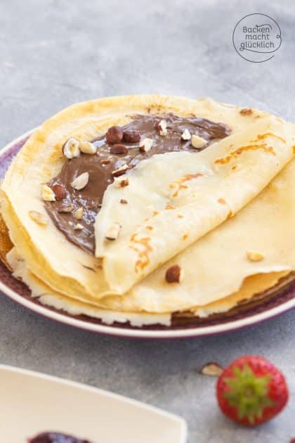 Gefaltete vegane Crêpes mit Nuss-Nougat-Creme und gehackten Haselnüssen