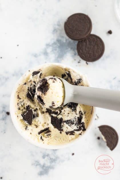 Eisportionierer hebt Kugel Oreo-Eis mit Keksstückchen aus Becher