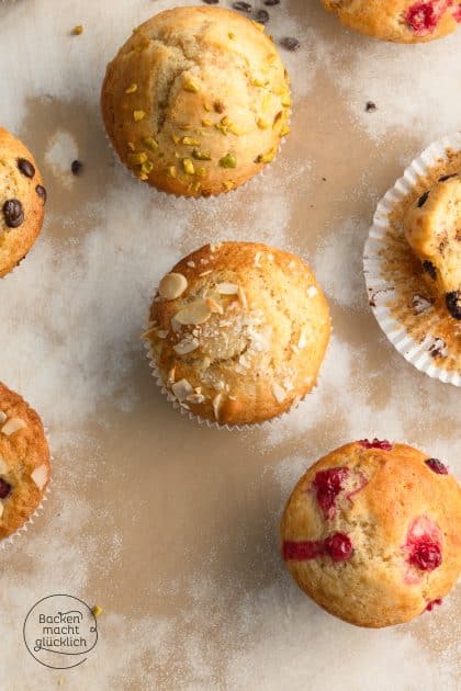 Verschiedene Muffins mit Pistazien, Mandelblättchen und Preiselbeeren auf Backpapier