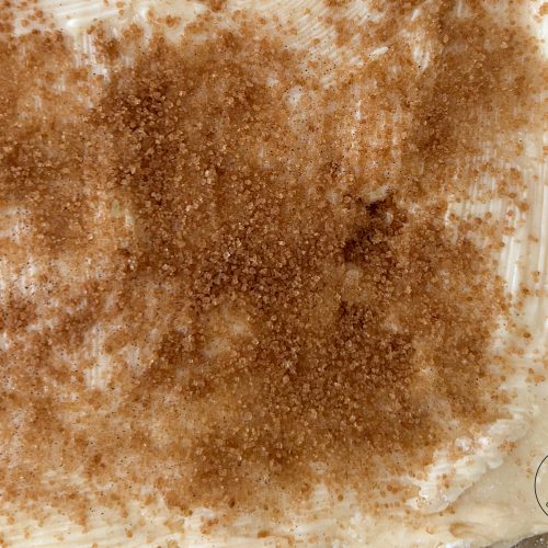 Ausgerollter Hefeteig mit Butter bestrichen und Zimtzucker bestreut