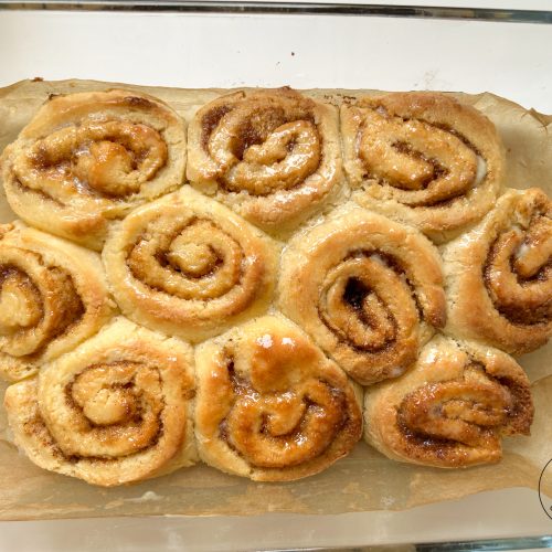 Frisch gebackene glutenfreie Zimtschnecken auf Backpapier in Auflaufform